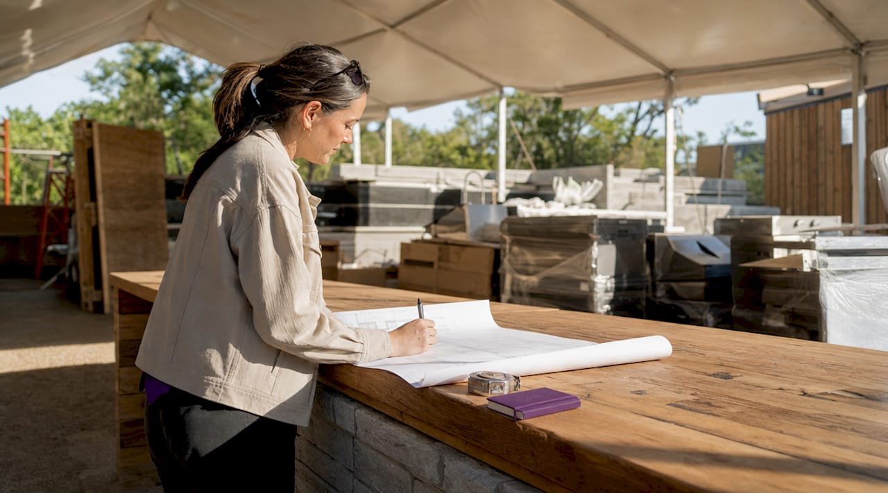 Project manager reviewing kitchen blueprints onsite