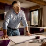 General contractor reviewing renovation plans on site