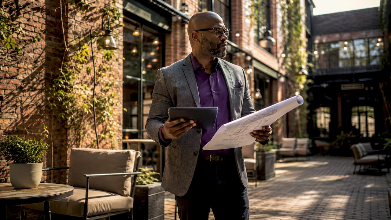 Architect reviewing blueprints in historic building lobby