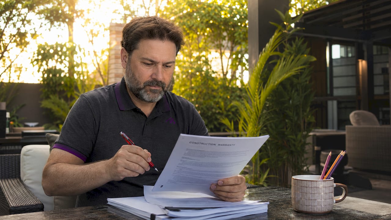 Property owner reviewing construction warranty document