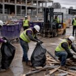 Construction workers cleaning construction site debris