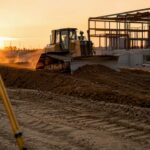 Bulldozer grading soil on commercial site