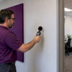 Consultant testing sound at an office partition